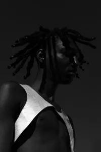 Black and white image of human looking away from camera and wearing a white garment