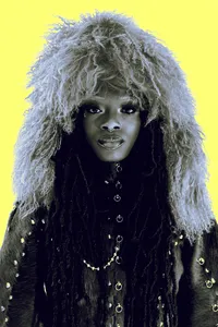 Black and white image of fashionable human looking at the camera with a neon yellow background