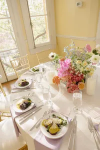 Formal table setting with silk white tablecloth, flowers and table setting for celebration of love
