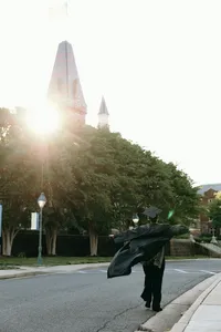 Graduate with arms extended and looking up at the sky celebrating