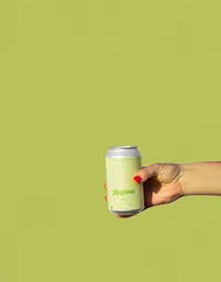 Pea green backdrop with pea green colored Anytime can with hand holding it with red nail polish