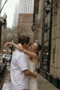 Couple embracing outside on a city sidewalk and smiling