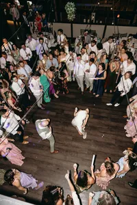 Ariel shot of couple dancing at celebration of love with attendees scattered all around them and celebrating