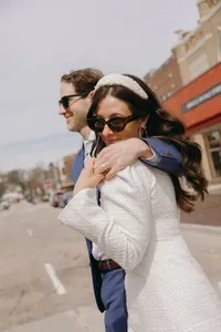 Couple walking with sunglasses on with one arm around their shoulders