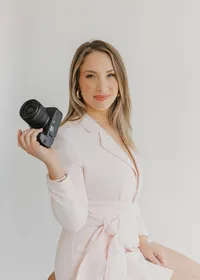 Emily DeLuke, Wilmington NC photographer, sitting with camera in hand during a branding photo session in downtown Wilmington