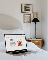 Dower & Associates Showit website displayed on a laptop in a softly styled bedroom.