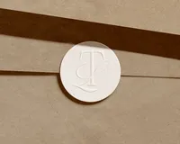 Tami Luger Real Estate TL monogram on a round seal closing a kraft envelope