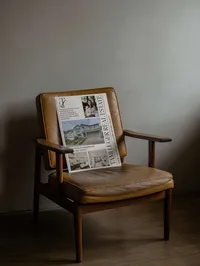 Tami Luger Real Estate oversized postcard propped on a vintage leather chair
