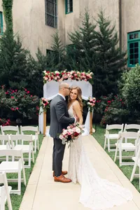 Bride and groom embracing at the aisle of their outdoor courtyard ceremony at Dresser Mansion
