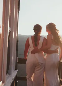A married couple looking at the sunset on a fire lookout.