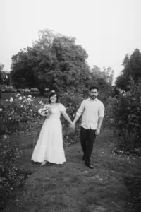 An engaged couple strolling and holding hands.