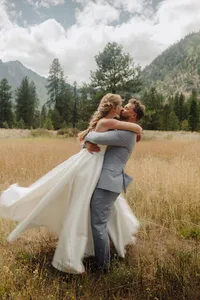 A groom lifting the bride in the air.