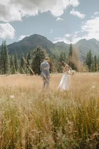 A married couple chasing each other on large field.