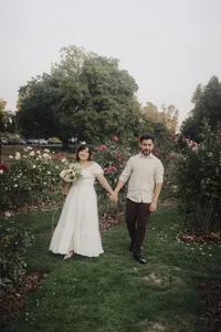 A candid moment of an engaged couple bumping each other at a rose garden.