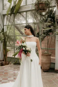 bruid met jurk en boeket met roze en witte bloemen