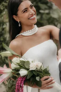detailfoto van trouwjurk met roze en wit boeket
