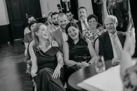 lachende gasten tijdens ceremonie bij bruiloft binnen