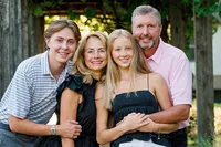 Outdoor family portrait by a Minneapolis family photographer featuring parents and their two children in Minnesota.
