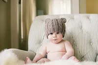 Minnesota photographer capturing a baby portrait with a knit bear hat during a cozy family photography session in Minneapolis.