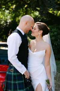 Bride and groom kissing beneath the trees at a Hatley Castle wedding