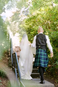 Bride and groom walking together through the gardens at Hatley Castle