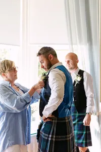 Family member helping the groom prepare before the ceremony