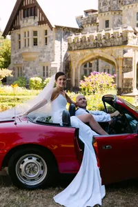 Bride relaxing in a red vintage car outside Hatley Castle