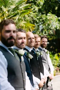 Groomsmen in kilts standing together outdoors at Hatley Castle