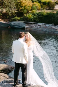 Bride and groom kissing on a rocky shoreline near Oak Bay Beach Hotel