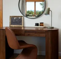 Walnut desk with modern leather chair, circle mirror, and a view of the Asheville mountains.