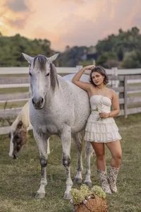 senior girl ina fenced field with her horse in a white dress indiana senior photography