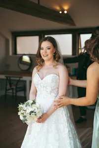 Bride being helped by a bridesmaid with her flowers before the ceremony