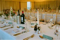 Wedding breakfast tables laid in a candlelit marquee at an Oxford wedding, 35mm film