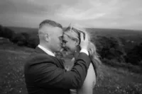 Bride and groom sharing an intimate forehead-to-forehead moment overlooking the countryside