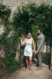 Bride and groom standing together outdoors surrounded by greenery