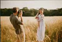 Man photographing his partner with a film camera in a meadow at Shotover, Oxford, 35mm film