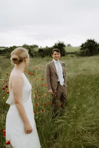 Bride and groom walking together across a field on their Oxfordshire wedding day