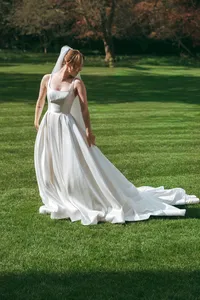 Bride from behind showing wedding dress train on the college lawn.