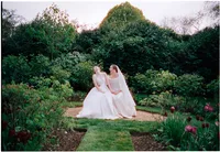 Two brides sitting together in the gardens at Worcester College Oxford, 35mm film wedding photograph