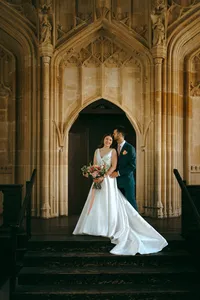 Bride and groom embracing in a Gothic stone doorway