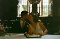 Couple kissing as they sign the register at an Oxford wedding, 35mm film