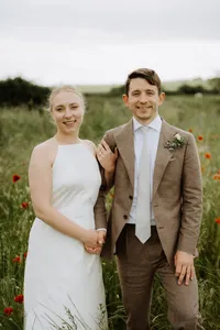 Bride and groom smiling together in a wildflower meadow on their wedding day