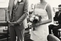 Black and white photo of groom holding the bridal bouquet