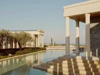 Luxury Mediterranean resort with infinity pool, palm trees, and modern architecture