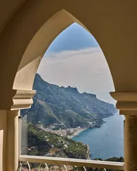 Scenic mountain lake view framed by a historic stone archway