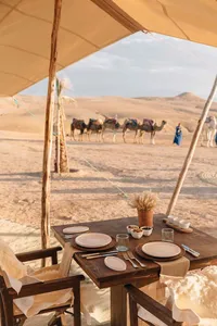 Luxury desert camp with traditional seating and panoramic sandy landscape