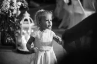 Black and white candid photograph of a flower girl during a Myrtle Beach wedding celebration, photographed by Amberlee Christey Photography.