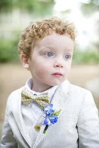 Young wedding attendant in a bow tie and boutonniere at Wild Dunes Resort in Isle of Palms SC photographed by Amberlee Christey.