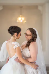 Two brides sharing a quiet wedding-day moment at BallenIsles in Palm Beach Gardens, Florida, photographed by Amberlee Christey Photography.