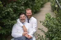 Two grooms laughing together at Commons Park during their Royal Palm Beach, Florida wedding.